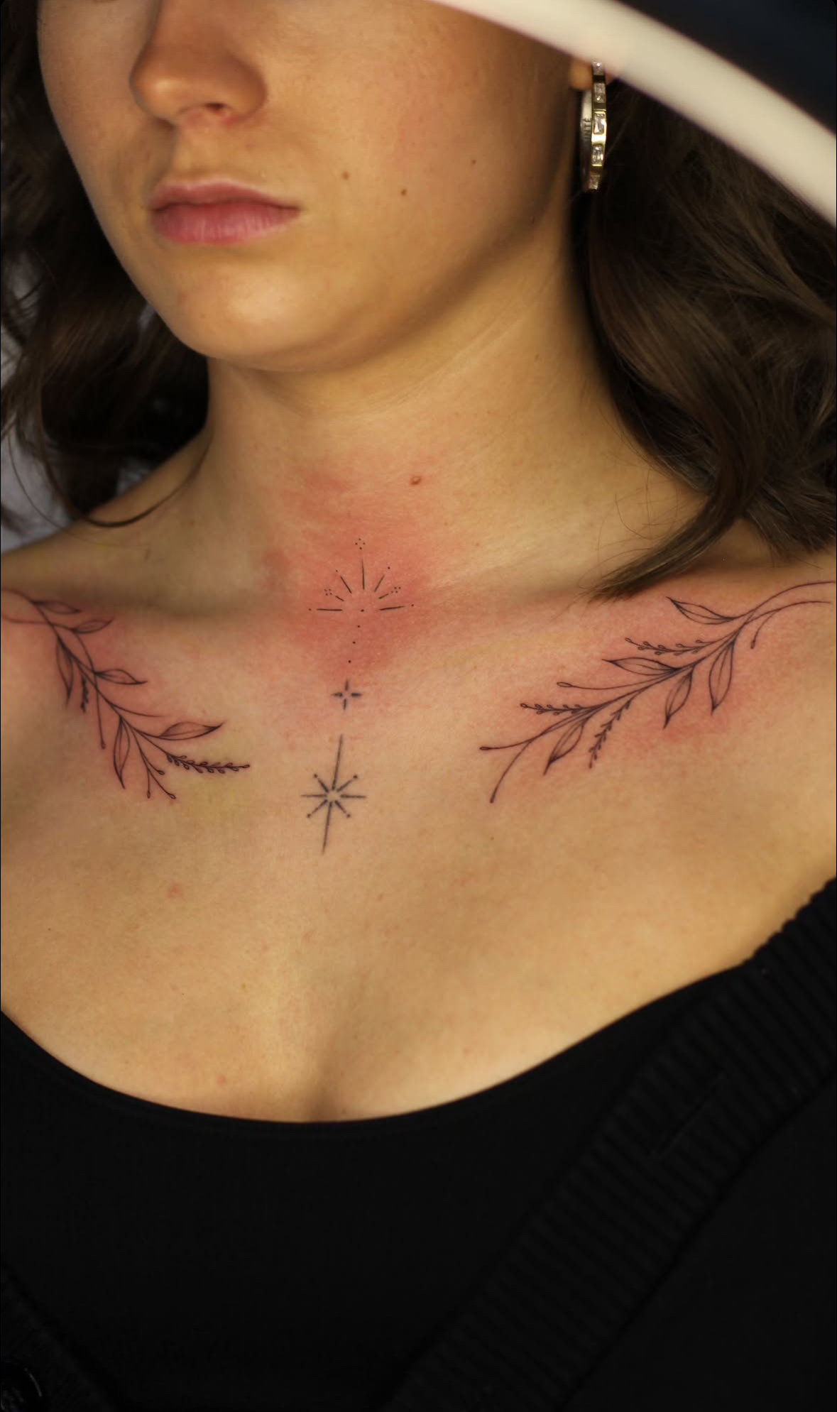 Botanical collarbone tattoos with fine line stars on the sternum